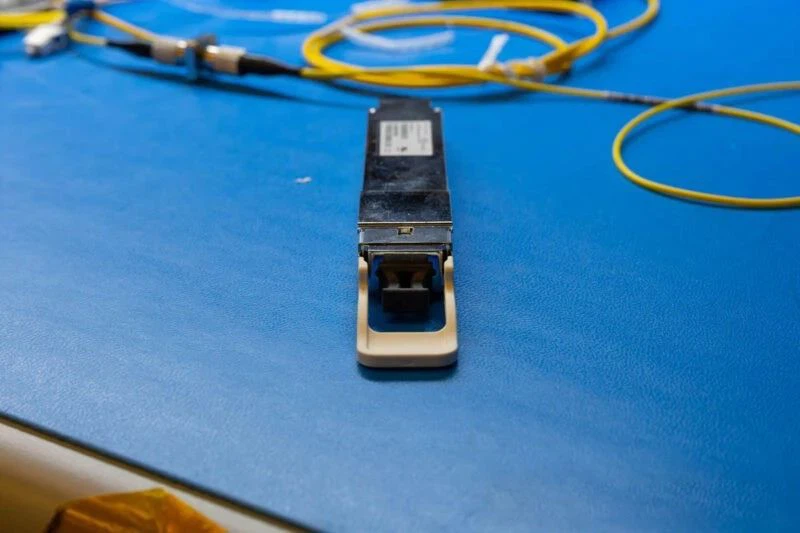 On the other end, we have the optical transmit and receive ports where the fiber optic cables are inserted. On the other end, we have the optical transmit and receive ports where the fiber optic cables are inserted.